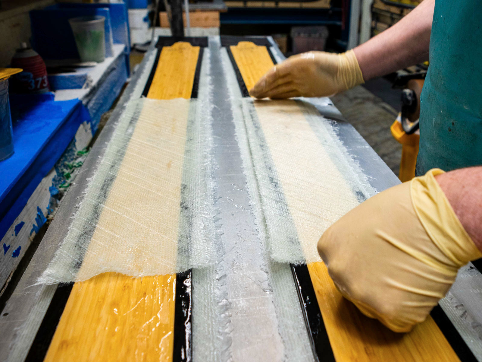 The extra-wide fiberglass binding mat placed underfoot during layup.